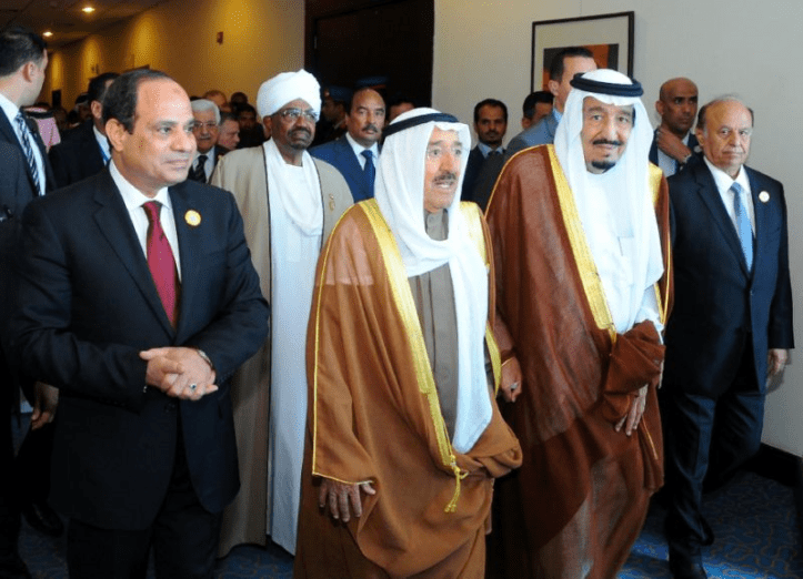 Meeting of the Arab leaders of the Arab League. The Egyptian president, El-Sisi, is seen in the front on the left, standing next to [in order from left-to-right] the Sudanese president (slightly at the back), the Amir of Kuwait (front), the king of Saudi Arabia (front), and the president of Yemen (front-right).