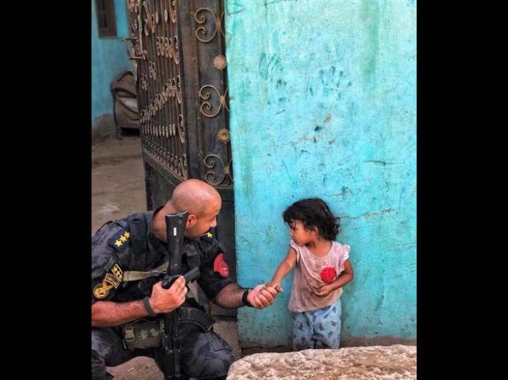 2018-09-22 Egyptian Police officer Ahmed Nafae with young girl during police operations in Cairo - Masrawy